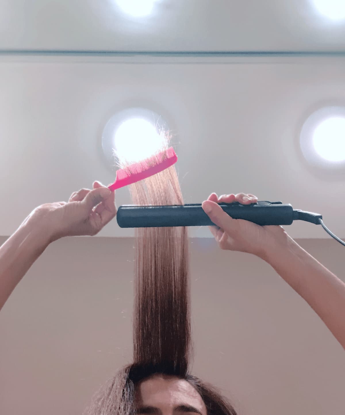 woman doing her hair using a hot flat iron to stra 2025 01 16 12 09 31 utc 1