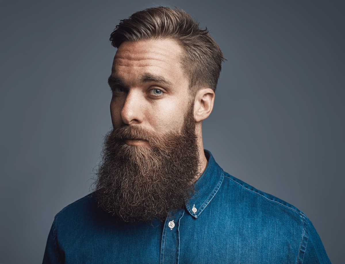 Guía para hombres: Los esenciales de Hey Joe para barba y cabello 1 bearded young hipster standing alone against a gra 2024 09 14 11 04 26 utc 1